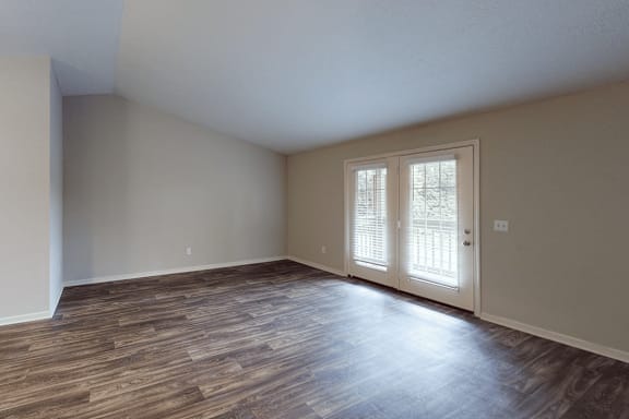 A room with a window and wooden flooring.