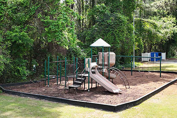 A playground with a slide, swings, and a small gazebo.
