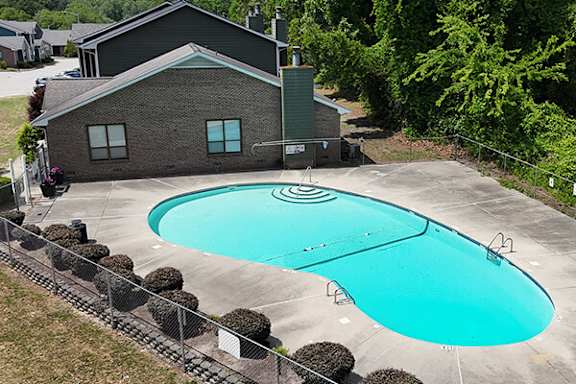 A small house with a pool in front.