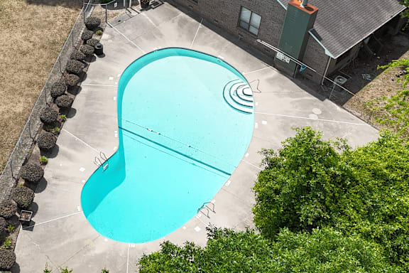 A small outdoor swimming pool surrounded by a stone wall.