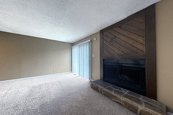 A room with a fireplace and a carpeted floor.