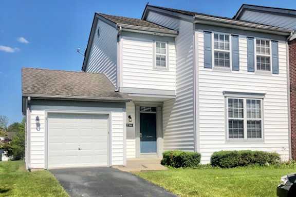 A two-story house with a garage and a driveway.