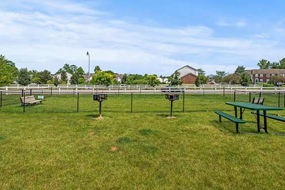 A park with picnic tables and a fence.