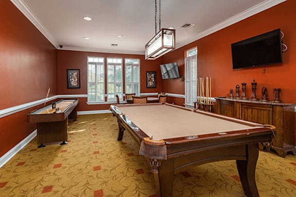 A pool table in a room with orange walls.