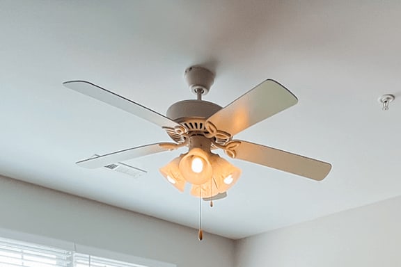 A ceiling fan with a light fixture hanging from the ceiling.