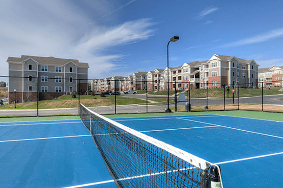 A tennis court with a blue surface and a white net.