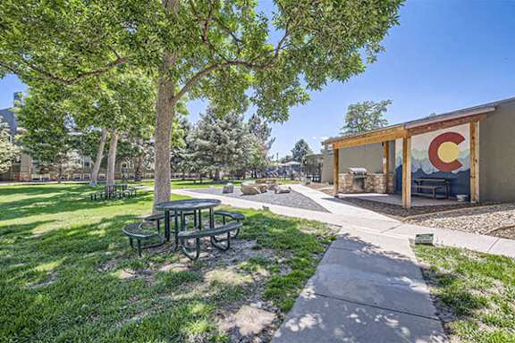 a park with picnic tables and a building