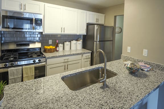 a kitchen with granite counter tops and stainless steel appliances