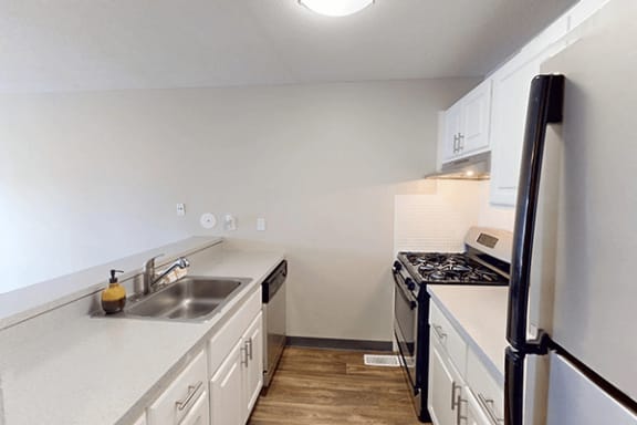 a kitchen with white cabinets and a sink and a refrigerator