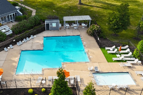 arial view of two swimming pools and a pool table and chairs