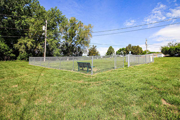 a park bench next to a fence in a field