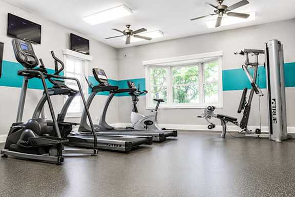 A gym with treadmills, elliptical machines, and a weight machine.