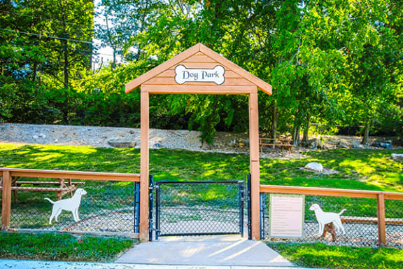 a dog park with two dogs walking through a gate