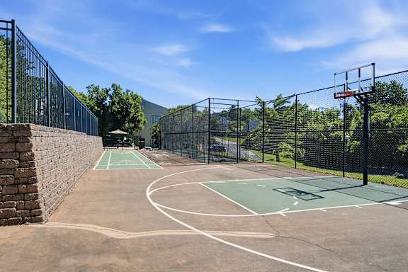 A basketball court surrounded by a fence.