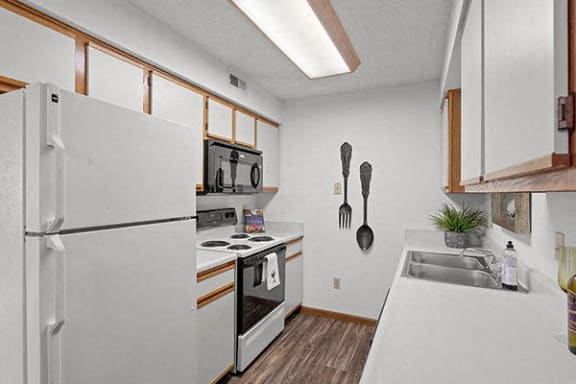 a kitchen with a white refrigerator and a sink