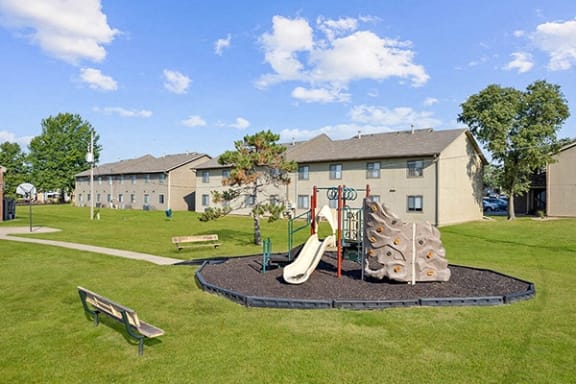 a playground in a park with buildings in the background