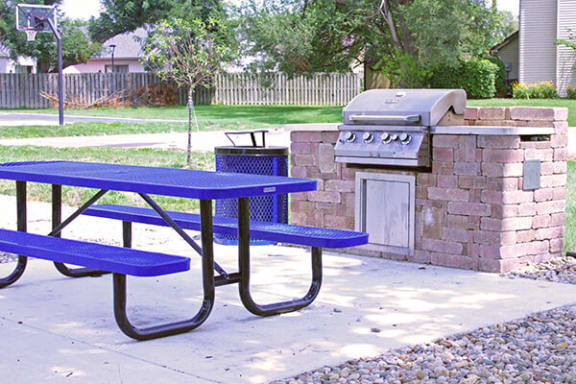 a blue picnic table sitting next to a barbecue grill