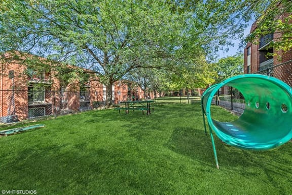 a green swing set in the middle of a yard