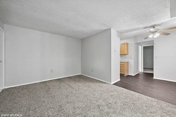 an empty living room with a ceiling fan