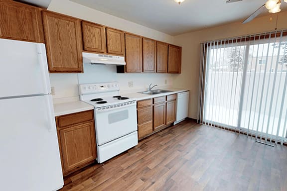 A kitchen with wooden cabinets and white appliances.