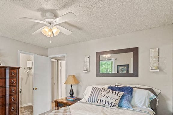 a bedroom with a bed and a ceiling fan
