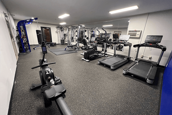 a spacious fitness center with cardio machines and other exercise equipment