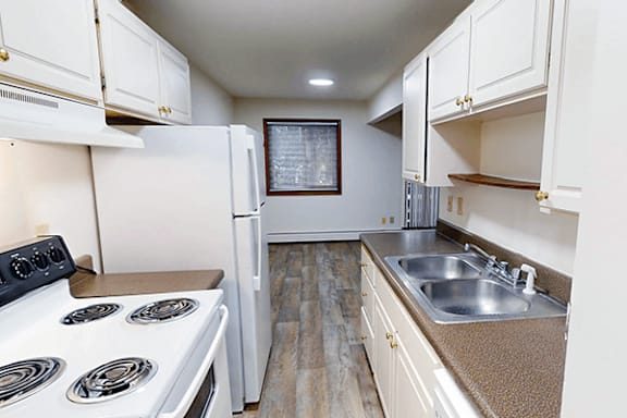 A kitchen with a white stove and a white refrigerator.