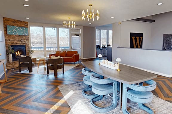A modern living room with a stone fireplace and a large wooden table.