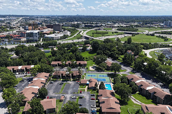 A bird's eye view of a residential area with a swimming pool and tennis court.