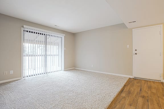 A room with a carpeted floor and a white door.