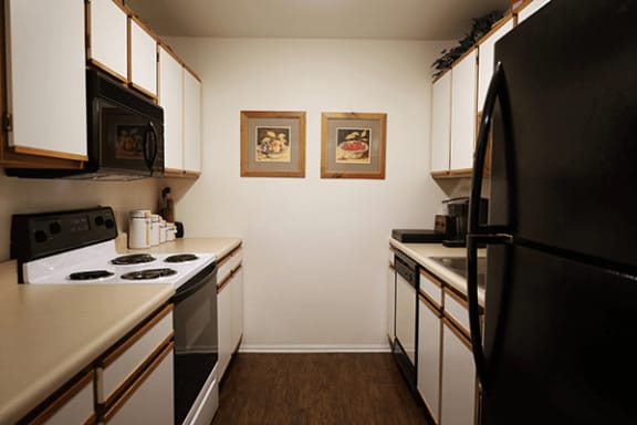 a kitchen with white cabinets and black appliances
