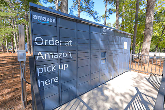 A sign for Amazon that says Order at Amazon, pick up here.