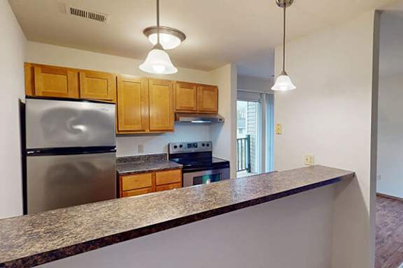 A kitchen with wooden cabinets and a granite countertop.