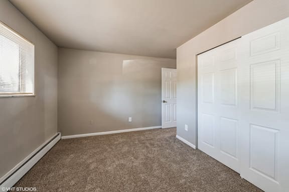 an empty bedroom with a closet and a door