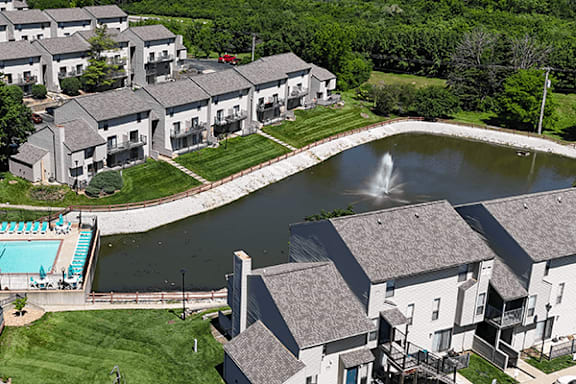 A large building complex with a pool and a fountain.