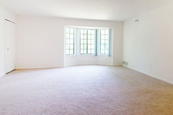 carpeting living room with beautiful bay window with natural light
