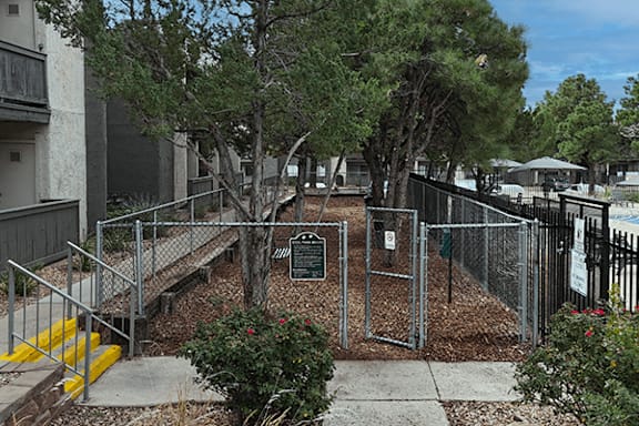 A small park with a plaque in the middle of a fenced area.