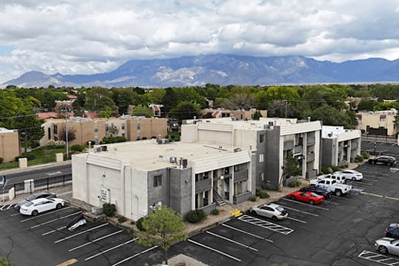 A parking lot with cars and a mountain in the background.