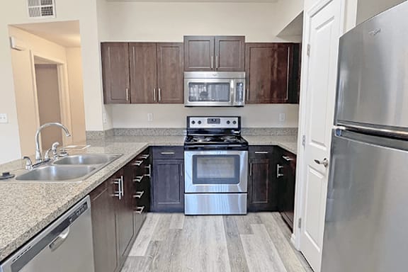 A kitchen with a stove top oven and a refrigerator.