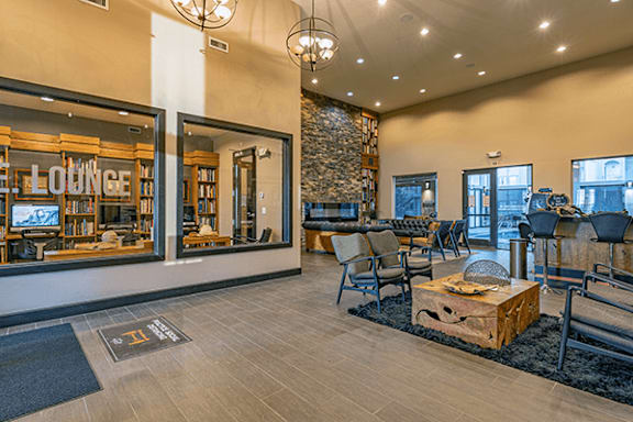 A spacious lounge area with a stone fireplace and comfortable seating.