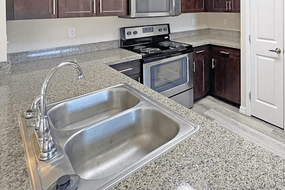 A kitchen with a stove, oven, and sink.