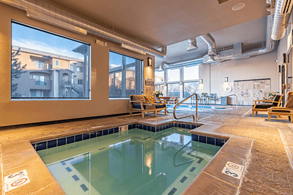 A small indoor pool with a glass barrier and a sign that says "no dive" on the floor.
