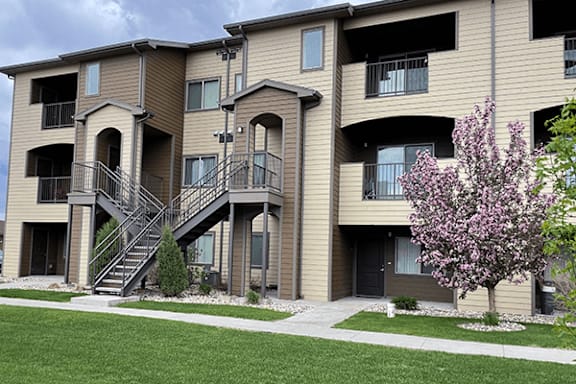 Apartment building with a tree in front of it.
