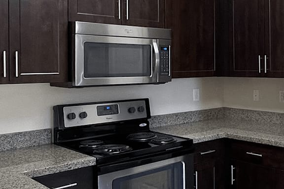 A kitchen with a black stove and a black microwave.