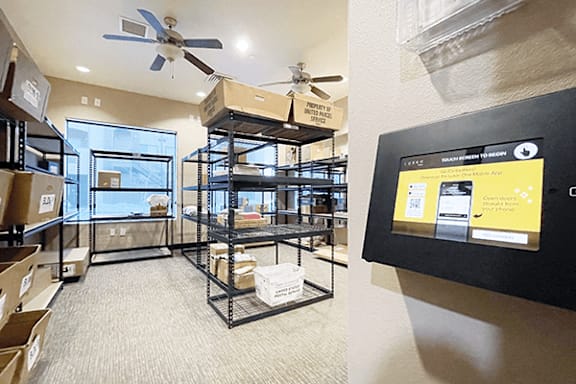 A room with a fan and a wall with a screen showing a website.