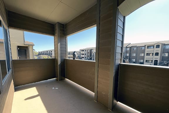 A balcony with a view of apartment buildings.