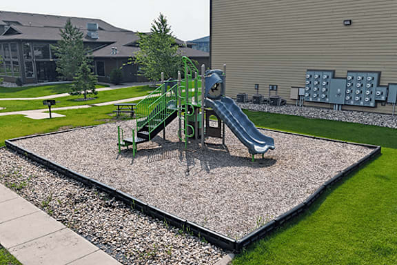 A playground with a green slide and a blue slide.