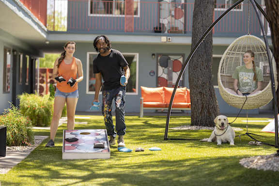 A man and a woman are playing a game on a lawn.