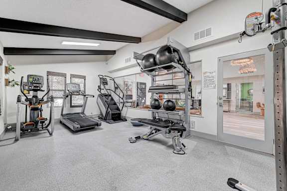 A gym with a variety of equipment including treadmills, weights, and exercise machines.