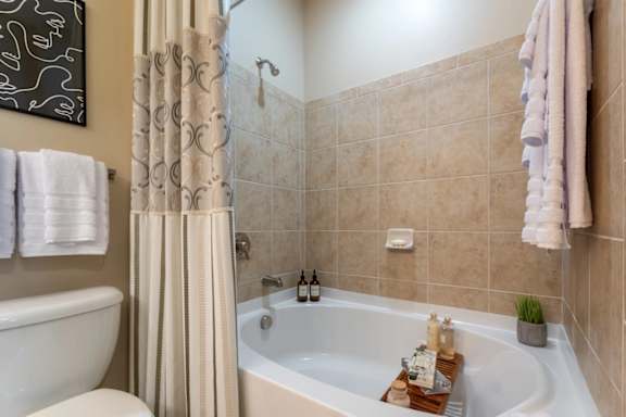 A bathroom with a white tub and a shower curtain.
